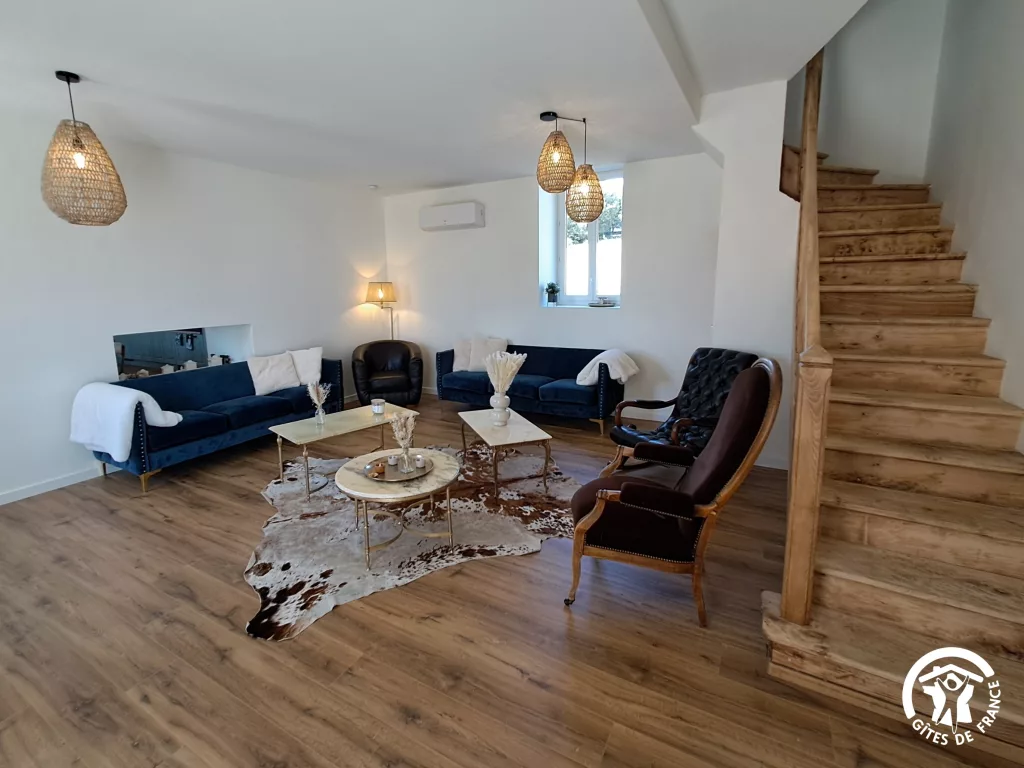 Salon avec canapés et fauteuils du gîte