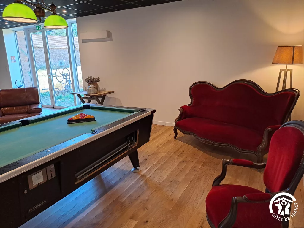 Billard et fauteuils rouges dans le salon de jeux