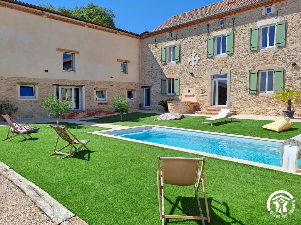 Piscine privée et façade en pierre du gîte