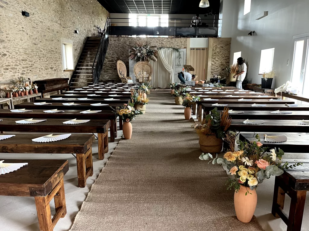 Cérémonie dans la grande salle, bancs décorés de fleurs