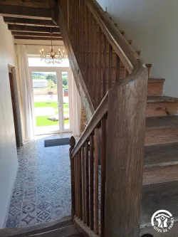 Entrée vitrée et escalier en bois au Domaine des Hirondelles