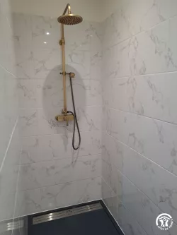 Douche en marbre à robinetterie dorée au Domaine des Hirondelles