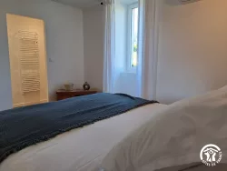 Chambre avec lit et fenêtre au Domaine des Hirondelles