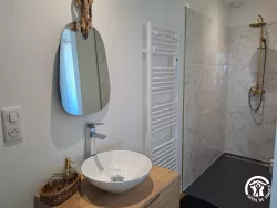 Salle de bain avec miroir et sèche-serviettes au Domaine des Hirondelles