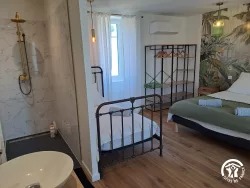 Chambre avec lit en fer forgé au Domaine des Hirondelles