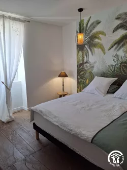 Chambre avec lit et lampe de chevet au Domaine des Hirondelles