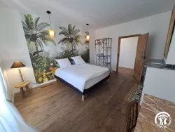Chambre avec papier peint tropical au Domaine des Hirondelles