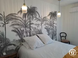 Chambre avec papier peint palmiers au Domaine des Hirondelles
