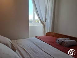 Chambre avec lit en bois et couvre-lit rouge au Domaine des Hirondelles