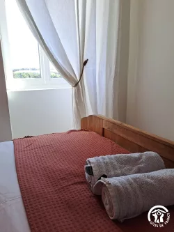 Chambre avec lit en bois et couvre-lit rouge au Domaine des Hirondelles