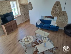 Salon avec canapé bleu et parquet au Domaine des Hirondelles