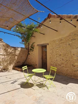 Terrasse avec porte en bois et mur en pierre au Domaine des Hirondelles