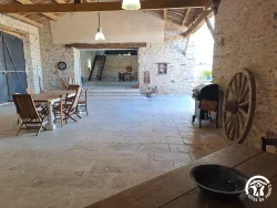 Salle ouverte avec tables et chaises en bois au Domaine des Hirondelles