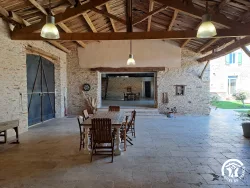 Salle ouverte sur la cour avec tables au Domaine des Hirondelles