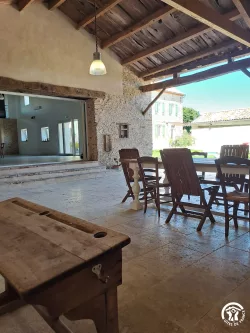 Tables et chaises devant une grande baie vitrée au Domaine des Hirondelles