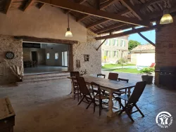 Grande salle avec table et vue sur le jardin au Domaine des Hirondelles
