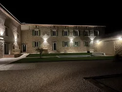 Façade du domaine éclairée de nuit au Domaine des Hirondelles
