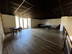 Salle lumineuse avec tables et billard au Domaine des Hirondelles