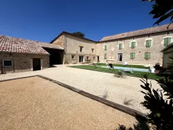 Cour pavée, pelouse et piscine au Domaine des Hirondelles