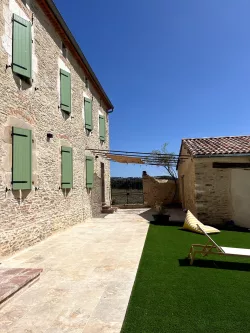 Façade en pierre aux volets verts au Domaine des Hirondelles