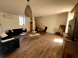 Salon avec canapé et escalier au Domaine des Hirondelles