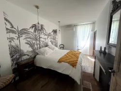 Chambre avec papier peint tropical au Domaine des Hirondelles