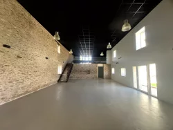 Grande salle avec escalier et mezzanine au Domaine des Hirondelles
