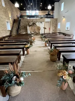 Allée de bancs décorés pour une cérémonie au Domaine des Hirondelles