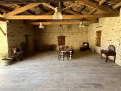 Salle en pierre avec table et chaises au Domaine des Hirondelles