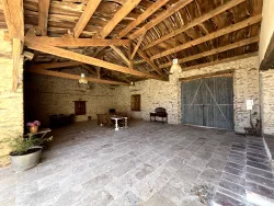 Salle en pierre avec charpente apparente au Domaine des Hirondelles